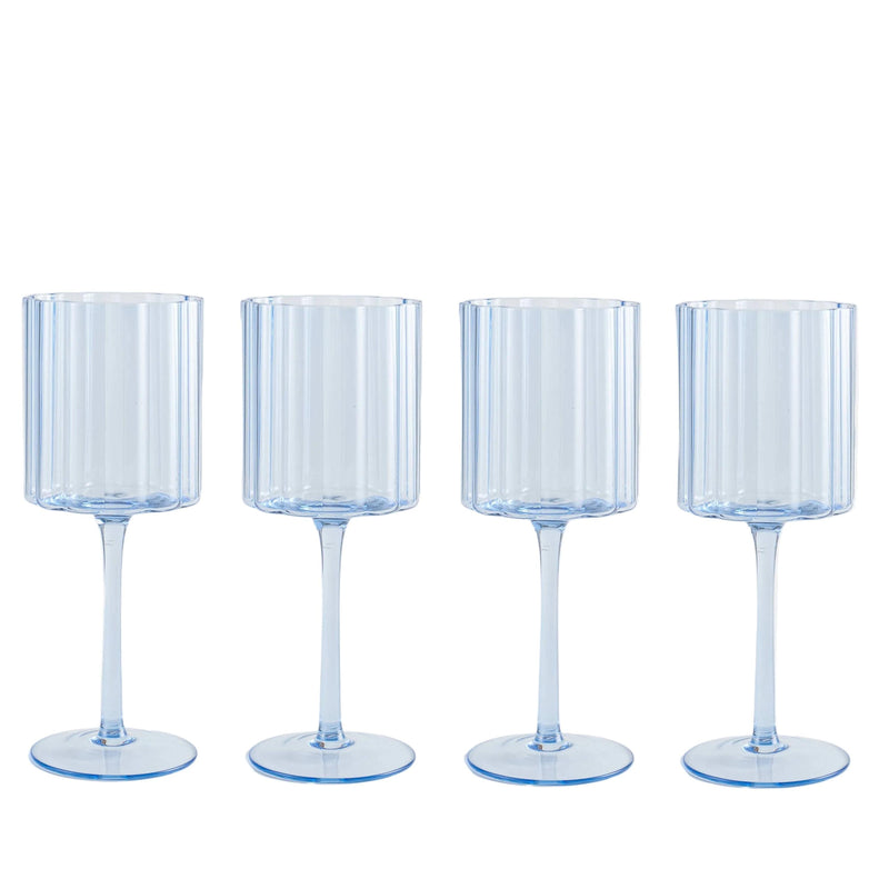Four ribbed glass goblets on a white background
